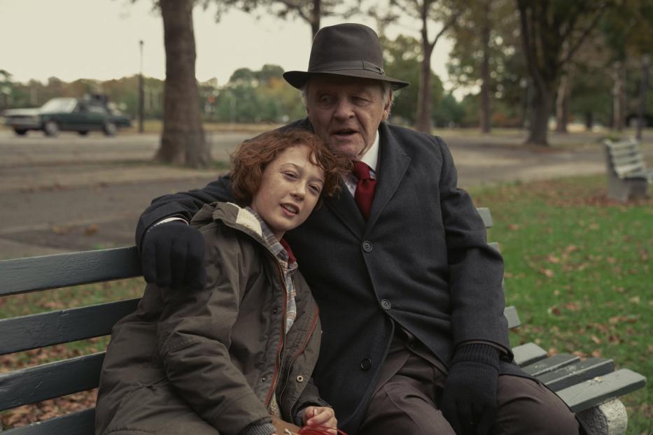 Anthony Hopkins sitzt mit einem Kind auf einer Parkbank.