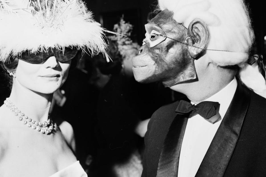 Zwei Personen in Kostümen und Masken auf einer Party.