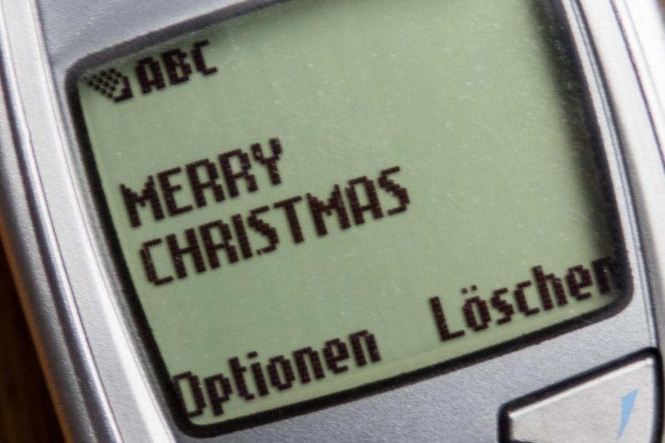 Ein altes Handy zeigt die Nachricht „Merry Christmas“ auf dem Display.