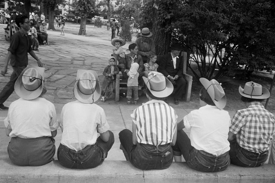 Eine Gruppe von Menschen mit Cowboyhüten sitzt im Park.