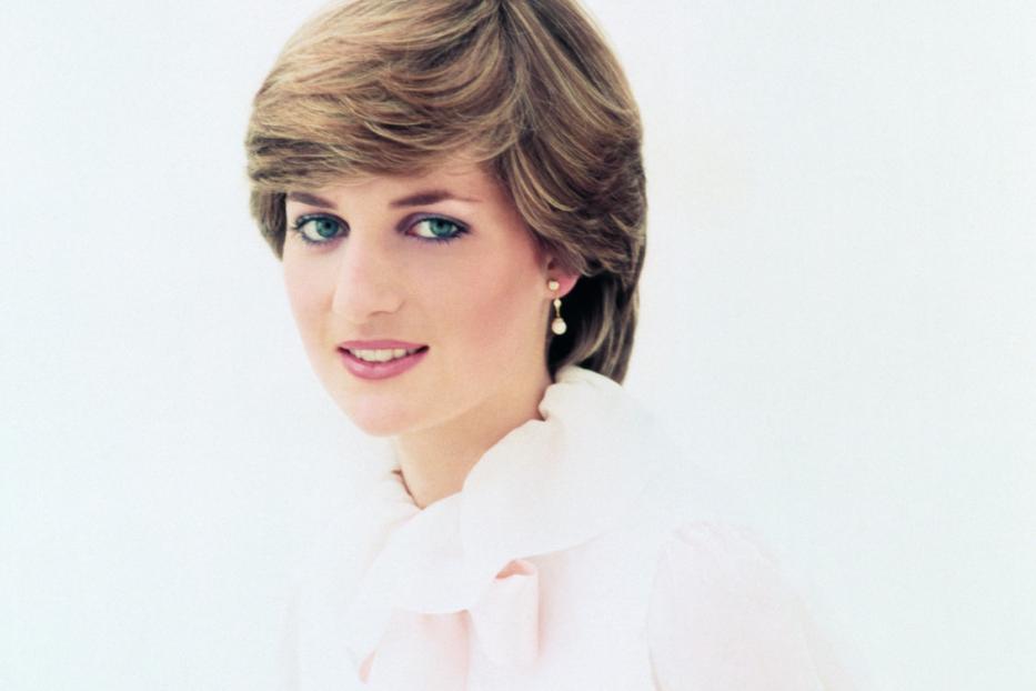 Ein Porträt von Prinzessin Diana mit blondem Haar und einem hellrosa Oberteil vor einem weißen Hintergrund.