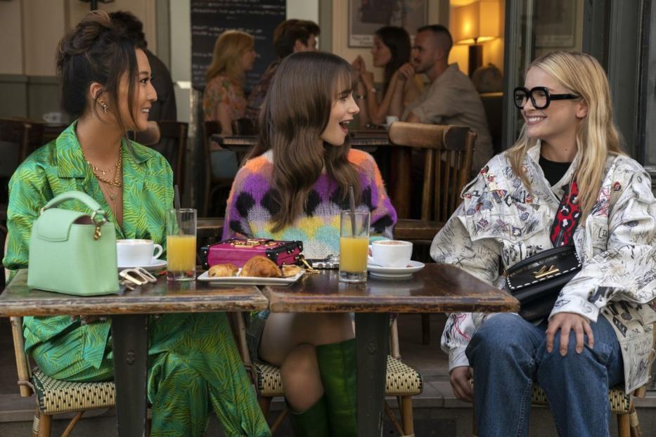 Drei Frauen sitzen in einem Café in Paris bei Kaffee und Croissants.