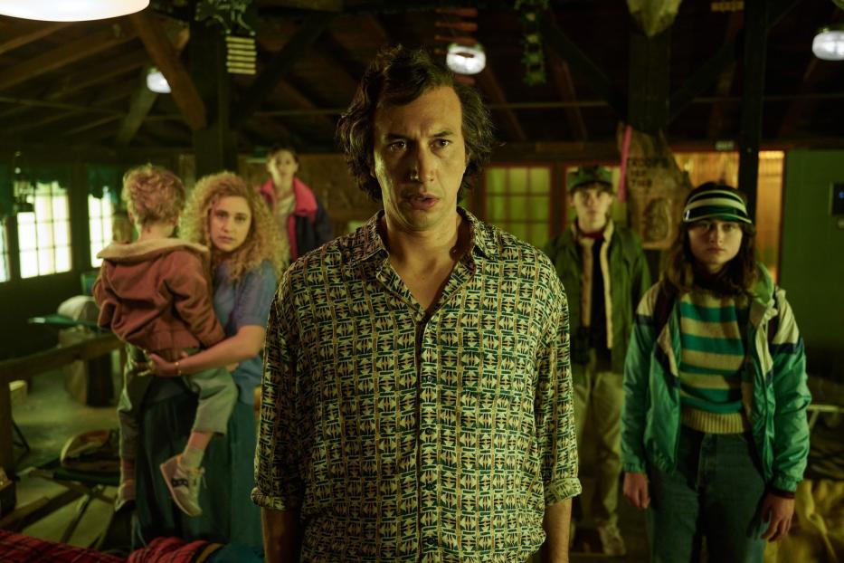 Adam Driver steht mit anderen Darstellern in einer Szene aus dem Film „White Noise“.