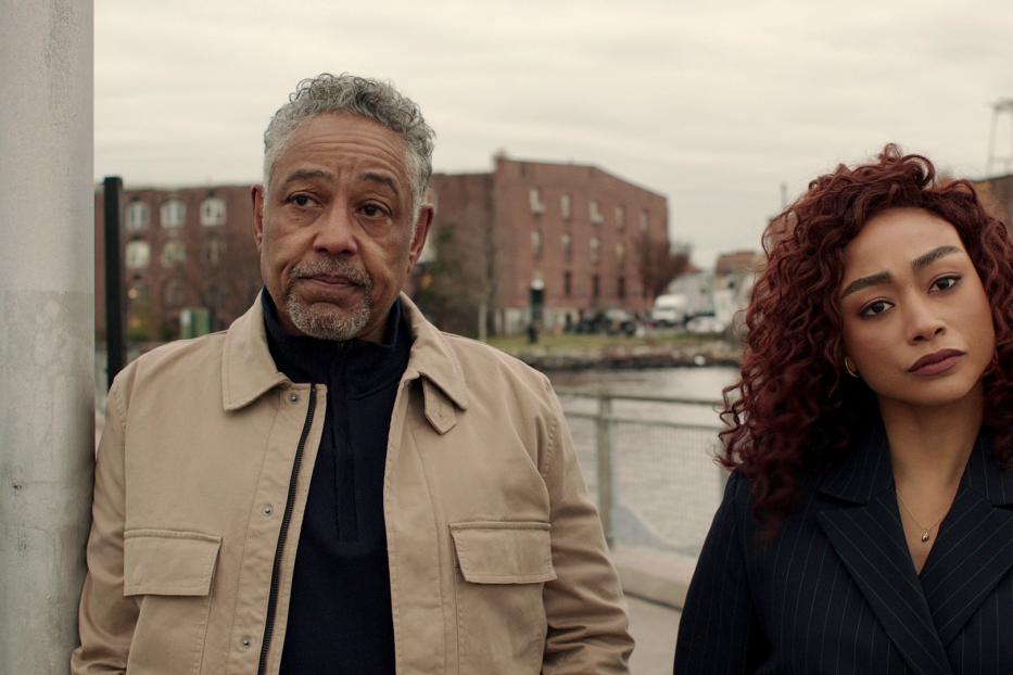 Giancarlo Esposito und Ruth Negga stehen zusammen vor einer städtischen Kulisse.
