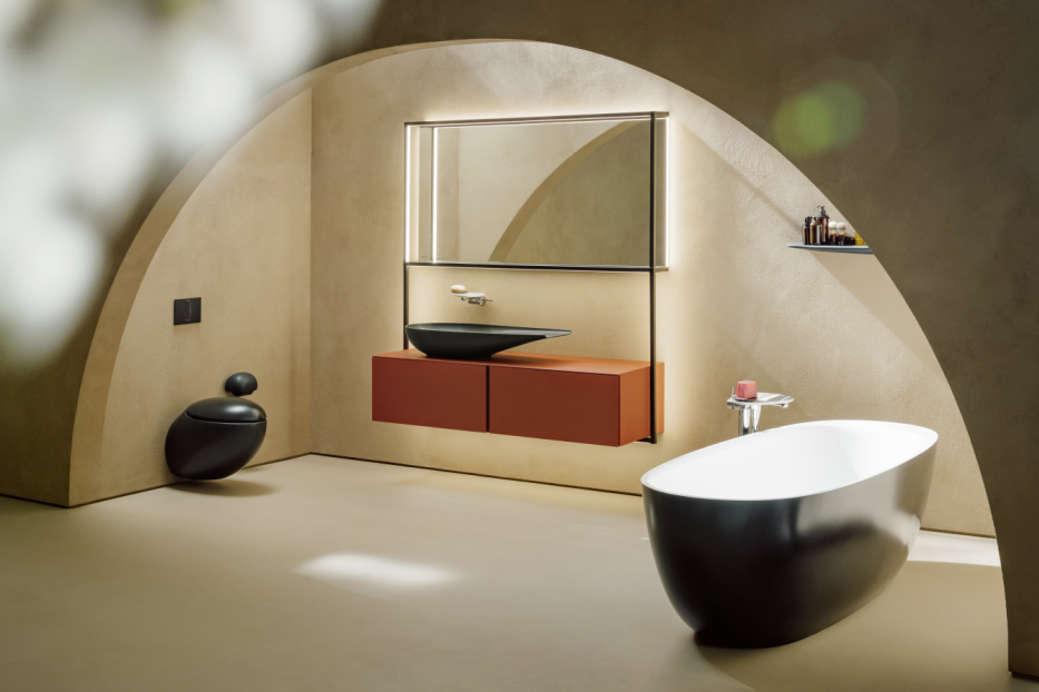 Ein modernes Badezimmer mit freistehender Badewanne, Waschtisch und Toilette in einem gewölbeartigen Raum.