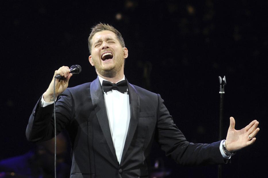 Michael Bublé singt mit weit geöffnetem Mund in einem schwarzen Smoking.