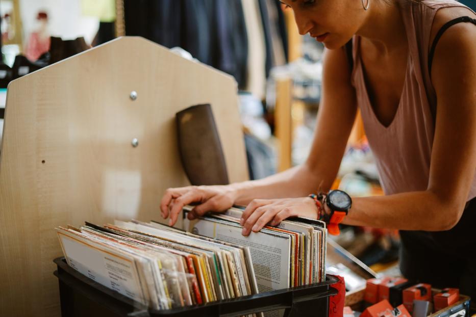 Eine Frau durchsucht eine Kiste mit Schallplatten.