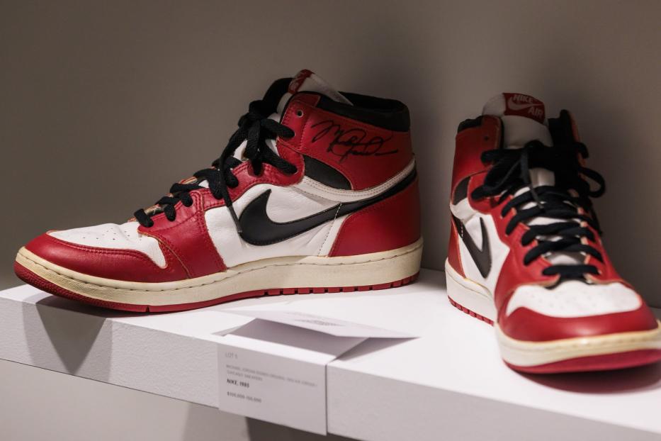 Zwei signierte Michael Jordan „Chicago“ Nike Air Jordan 1 High Sneaker von 1985 stehen auf einem Regal.