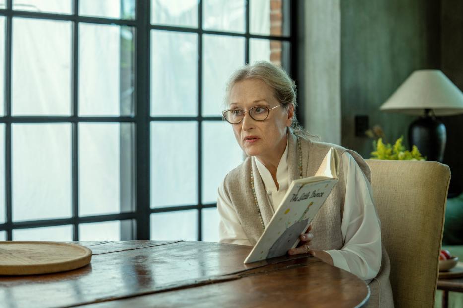 Meryl Streep liest am Tisch sitzend „Der kleine Prinz“.