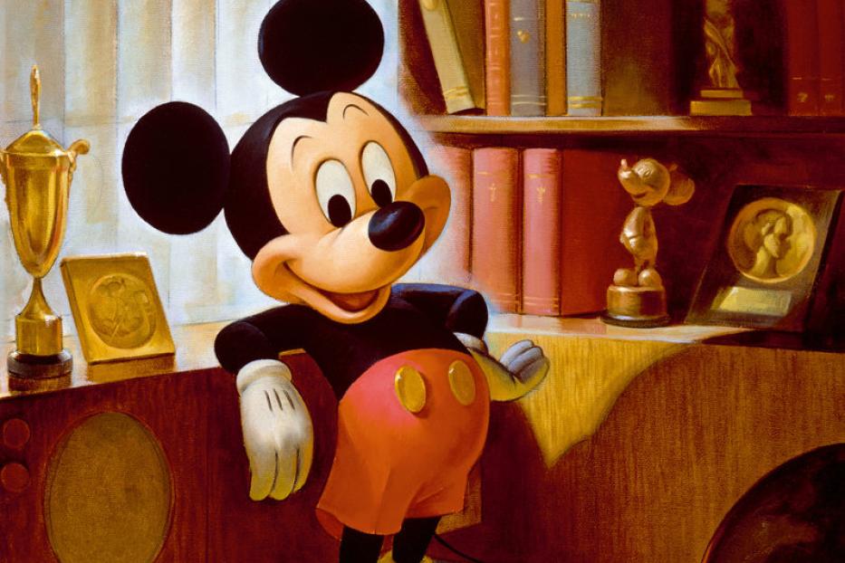 Micky Maus steht in einem Raum mit Trophäen und Büchern.