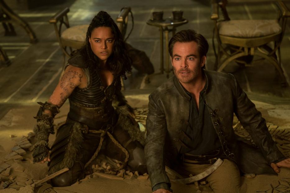 Michelle Rodriguez und Chris Pine in Kostümen knien auf dem Boden.