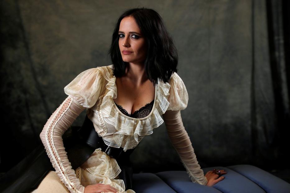 Eva Green posiert in einem elfenbeinfarbenen Kleid mit Rüschen und einem breiten Gürtel.