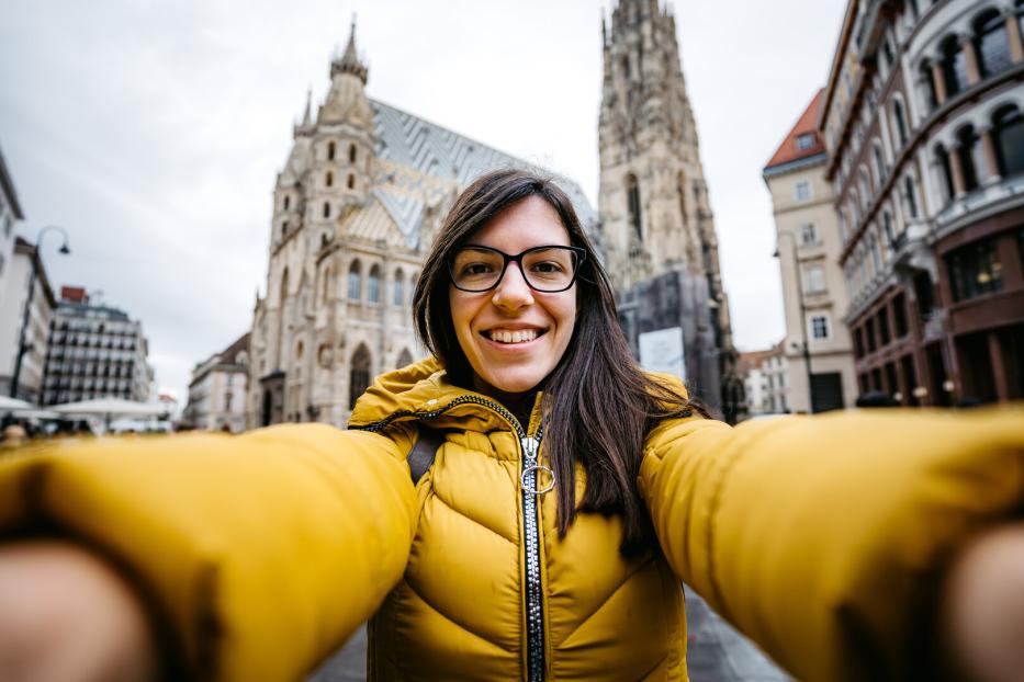 Eine Frau macht ein Selfie vor dem Stephansdom in Wien.