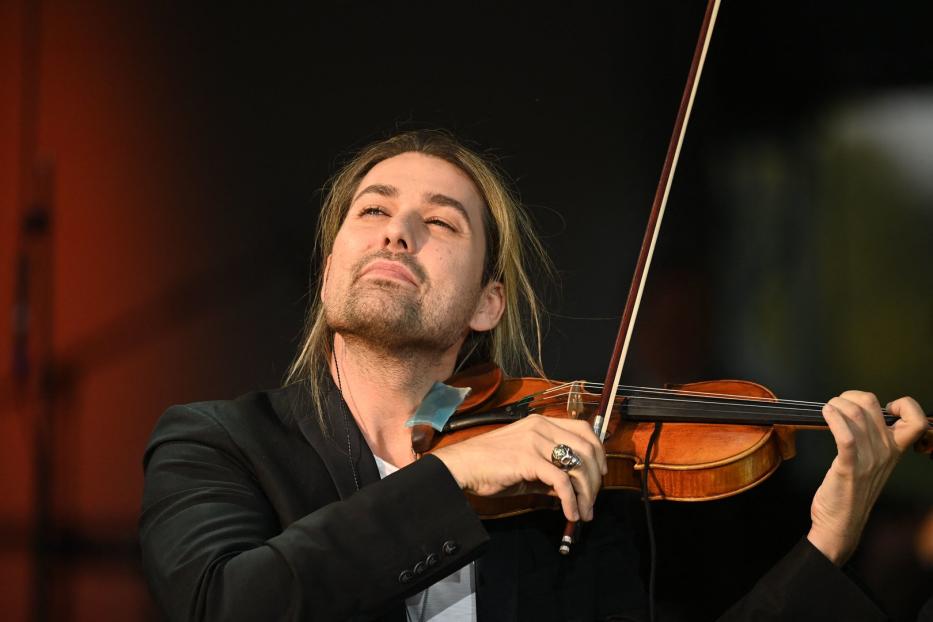 Ein Mann mit langen blonden Haaren spielt Violine.