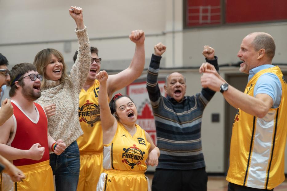 Das Team „Friends“ und ihr Trainer jubeln gemeinsam auf dem Basketballfeld.