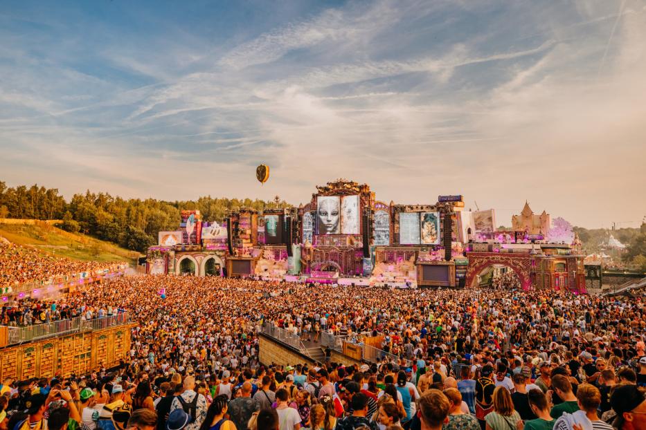 Eine riesige Menschenmenge versammelt sich vor einer aufwendigen Bühne auf einem Musikfestival.