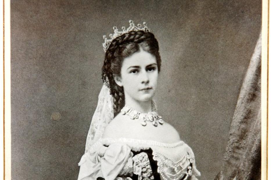 Ein Porträt von Kaiserin Elisabeth von Österreich in einem aufwendigen Ballkleid mit Schmuck und Fächer.