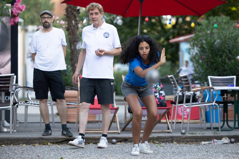 Eine junge Frau spielt Pétanque auf der Summerstage in Wien.