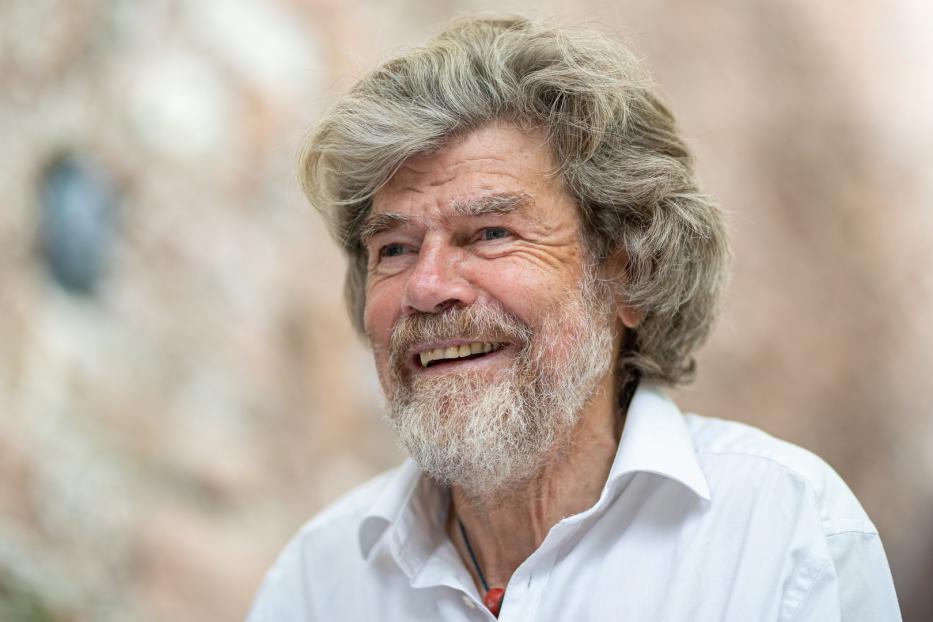 Reinhold Messner lächelt in einem weißen Hemd.