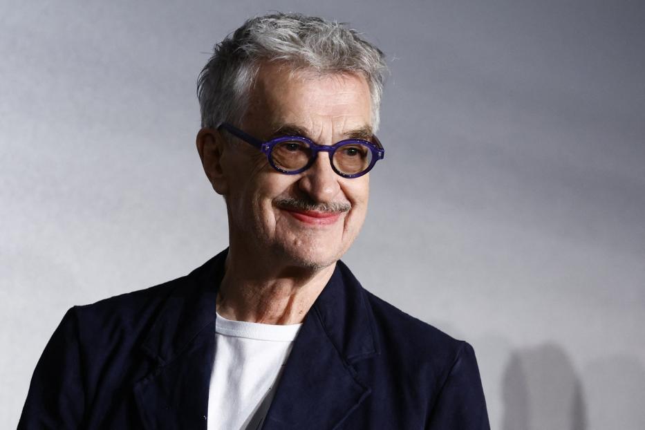 Der deutsche Schauspieler Udo Kier mit lila Brille lächelt.