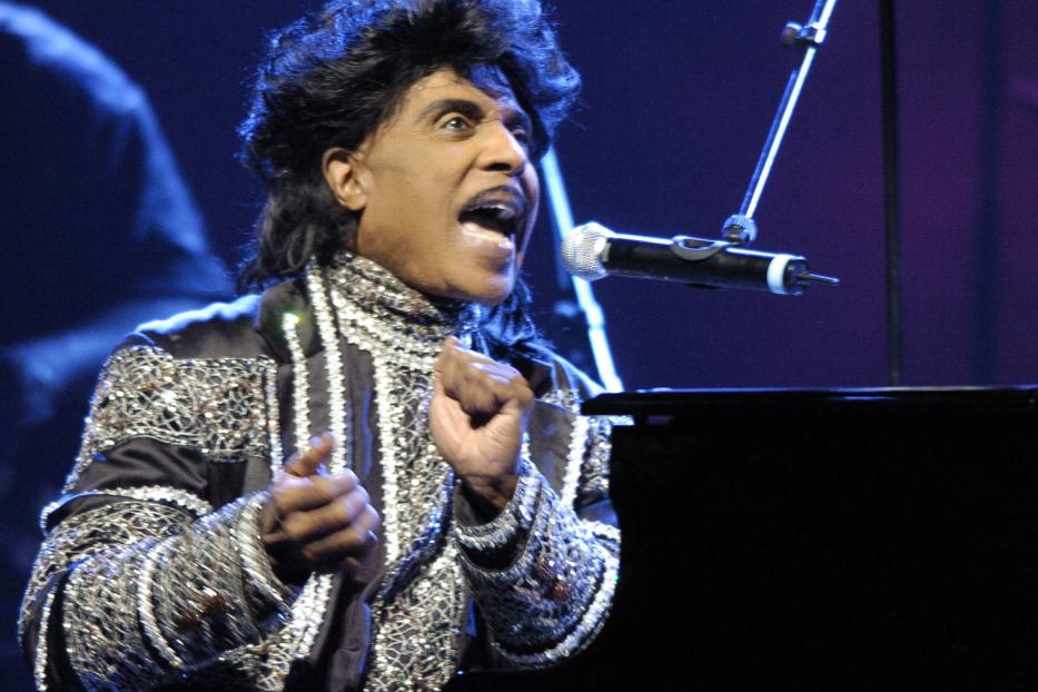 Little Richard singt am Klavier mit funkelndem Jackett.