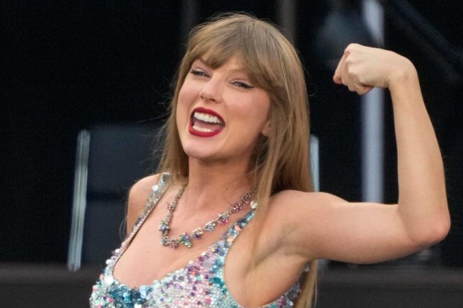 Taylor Swift posiert in einem glitzernden Body und zeigt ihren Bizeps.