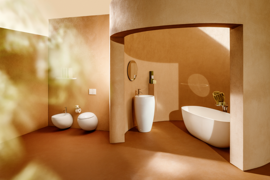 Ein Badezimmer in Erdtönen mit freistehender Badewanne, Waschtisch und Toilette.