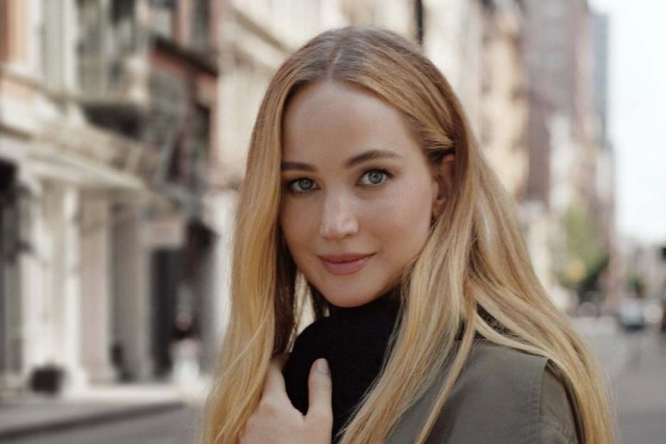 Jennifer Lawrence trägt einen Trenchcoat und eine Uhr auf einer Straße.