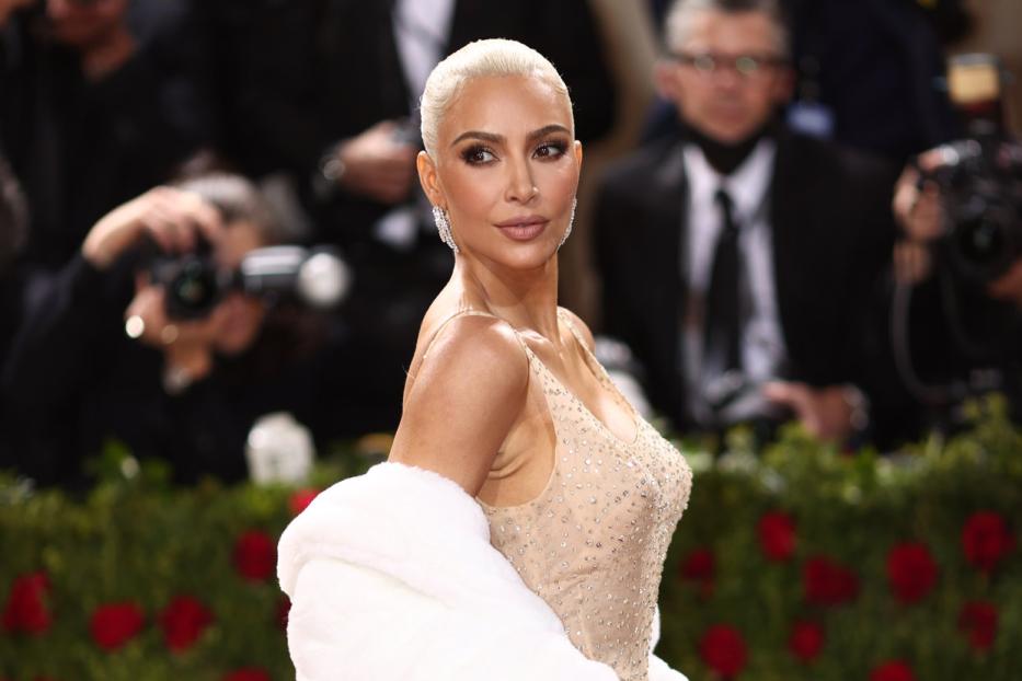 Kim Kardashian posiert in einem mit Schmucksteinen besetzten Kleid und einer weißen Stola.