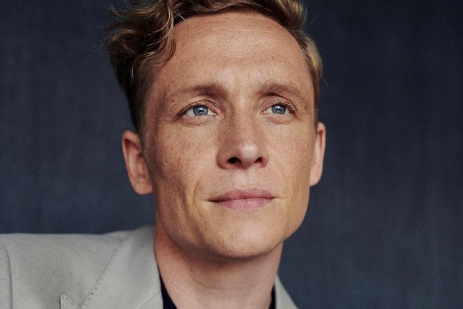 Ein Porträt des Schauspielers Toby Jones in einem hellgrauen Sakko.