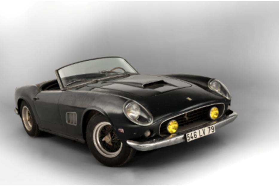 Ein schwarzer Ferrari 250 GT California Spider steht vor einem grauen Hintergrund.