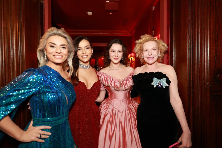 Vier Frauen in Abendkleidern posieren für ein Foto.