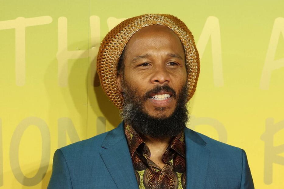 Ziggy Marley trägt einen Hut und einen blauen Anzug.