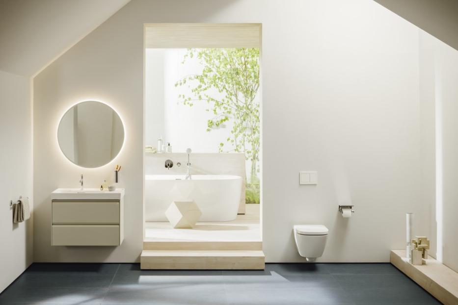 Ein modernes Badezimmer mit Badewanne, Waschtisch mit Spiegel und Toilette.