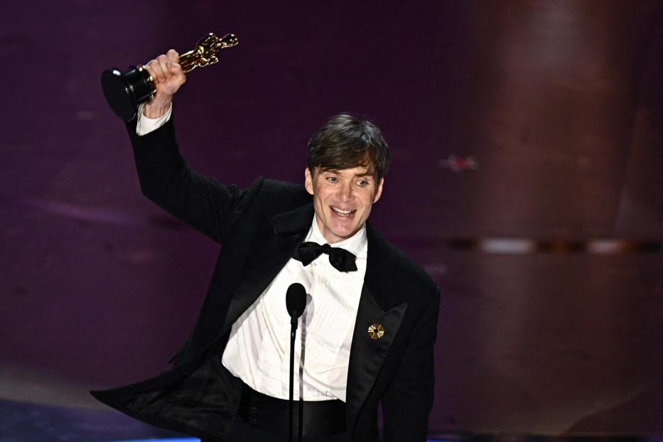 Cillian Murphy hält seinen Oscar in die Höhe.