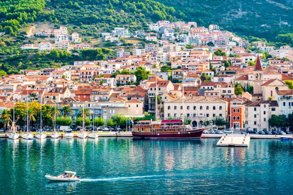Blick auf die Küstenstadt Supetar in Kroatien mit Booten im Hafen.