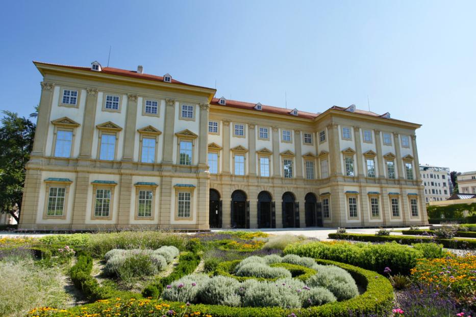 Das Gartenpalais Liechtenstein mit einem kunstvoll angelegten Garten im Vordergrund.