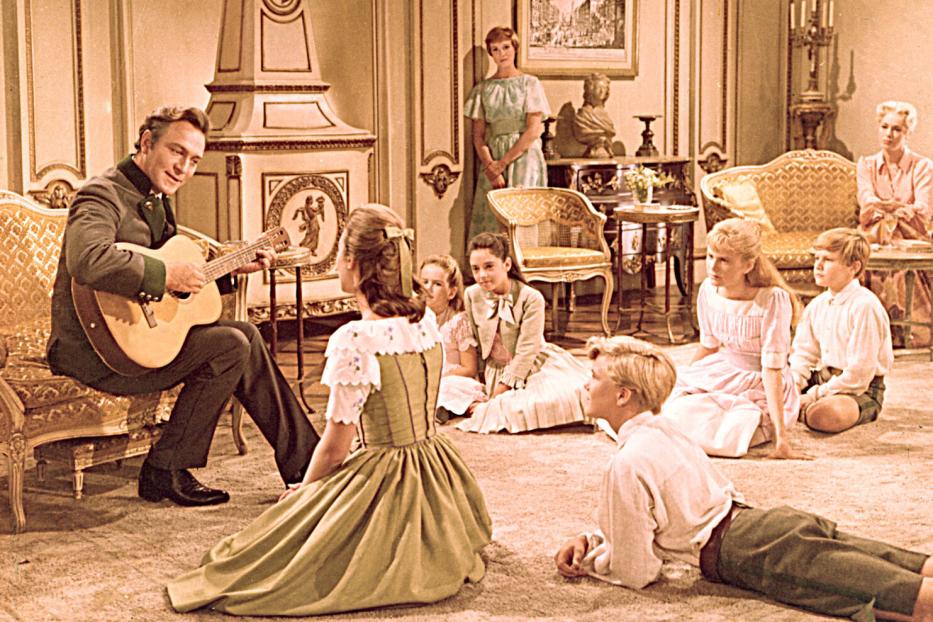 Szene aus „The Sound of Music“: Captain von Trapp spielt Gitarre für seine Kinder.
