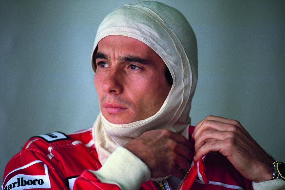 Ayrton Senna mit Sturmhaube und Rennanzug vor einem Rennen.