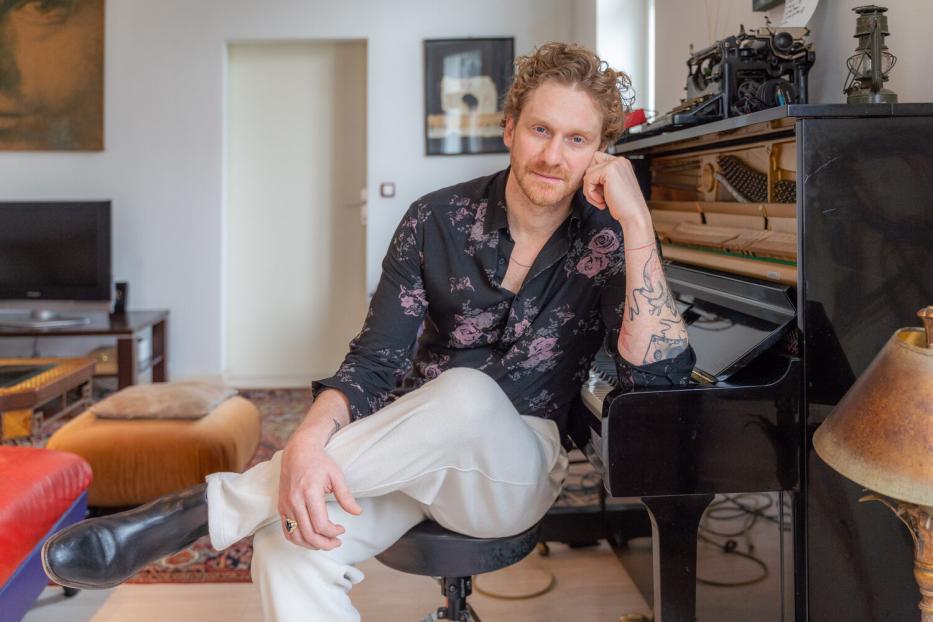 Lucas Fendrich sitzt an einem Klavier in einem Wohnzimmer.