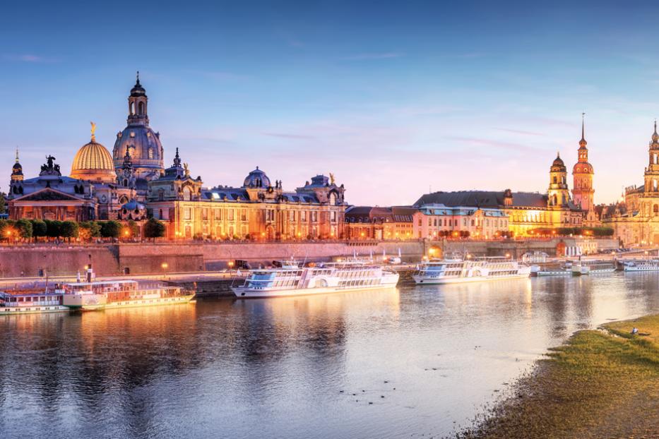 Die Altstadt einer Stadt von der anderen Seite des Flusses gesehen, in der Abenddämmerung.