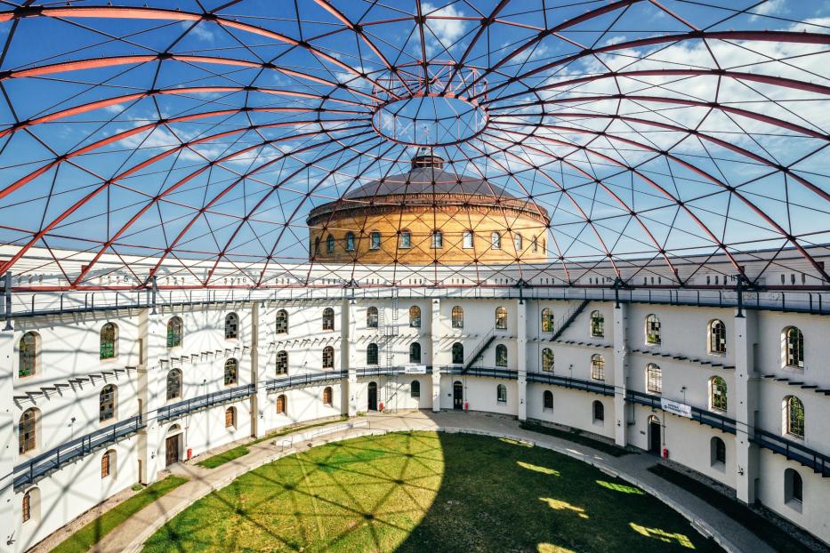 Innenansicht des EUREF-Campus in Berlin mit roter Stahlkuppel und begrüntem Innenhof.