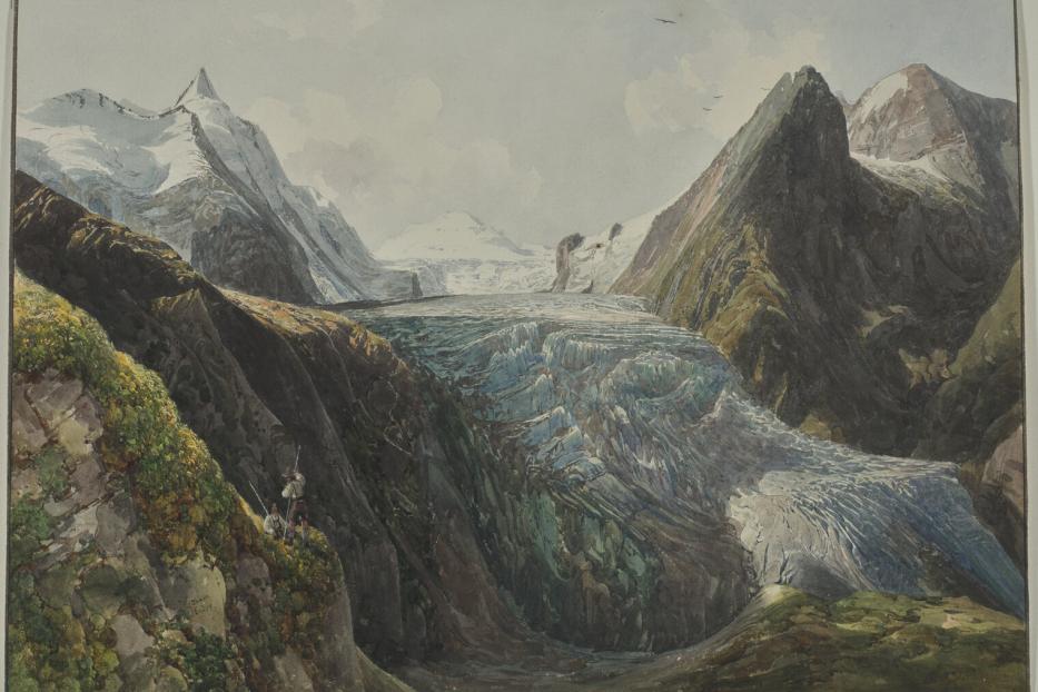 Ein Gletscher erstreckt sich zwischen hohen Bergen, während drei Personen am Rande einer Klippe stehen.