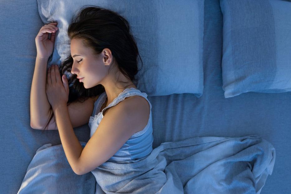 Frau schläft im Bett.