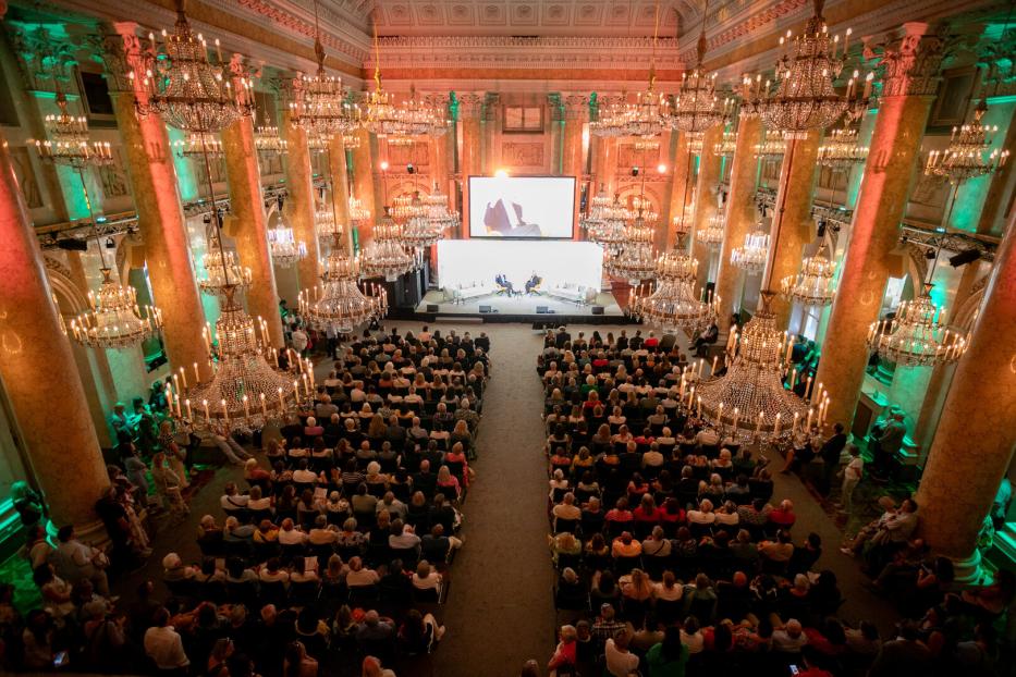 Ein großer Saal der Wiener Hofburg mit Lüstern und vielen Menschen.