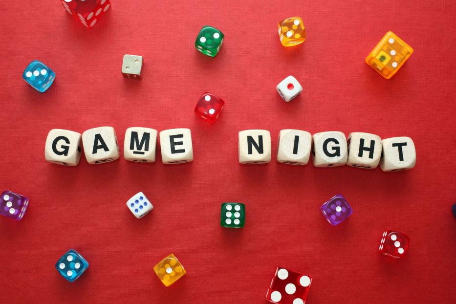 Wooden word dice spell 'Game Night' with multicoloured dice around it.