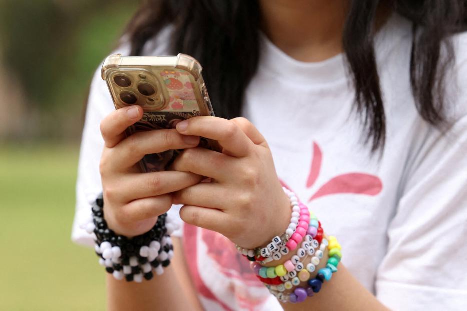 FILE PHOTO: Teens discuss Australia's social media ban for under-16s, set to take effect December 10, in Sydney