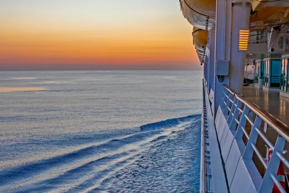 Blick vom Kreuzfahrtschiff auf das ruhige Meer bei Sonnenuntergang.