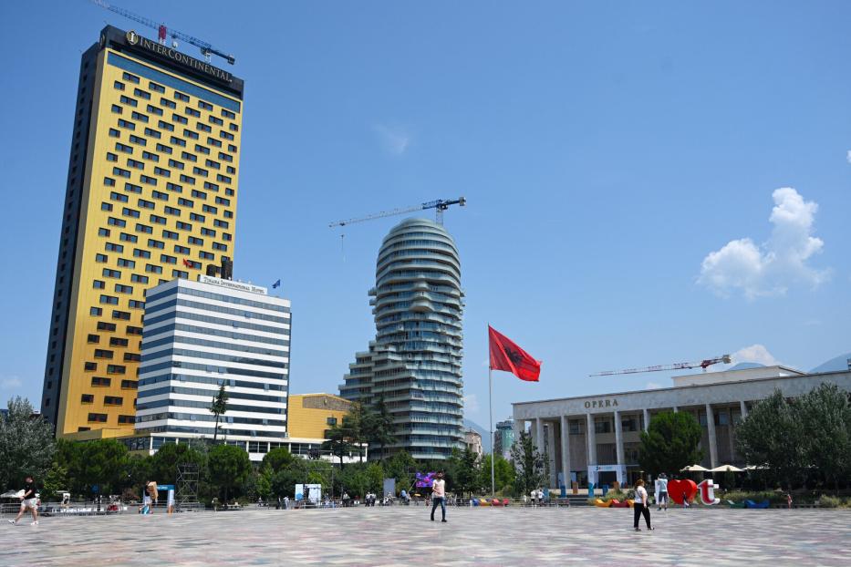 Der Skanderbeg-Platz in Tirana mit dem InterContinental Hotel, dem markanten Eye of Tirana Hochhaus und der albanischen Flagge vor der Oper.