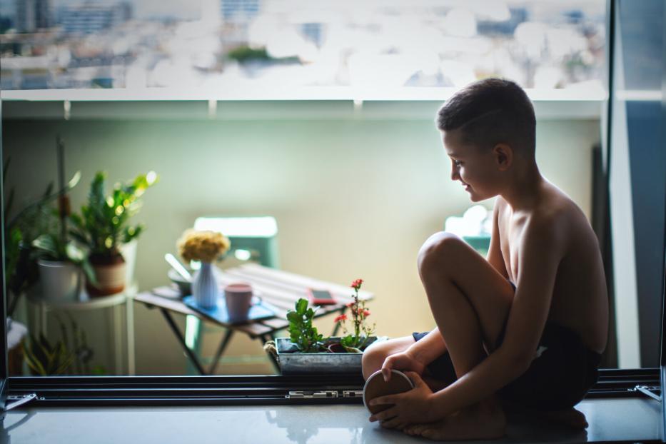 Boy Finds Joy Sitting by the Window.